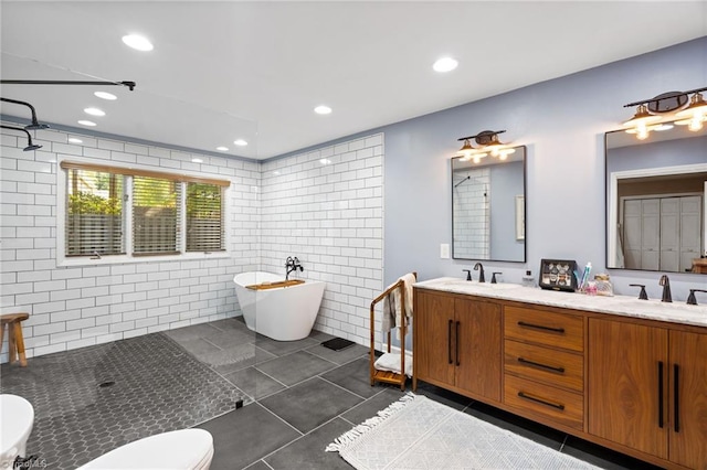 6404 Muirfield Dr, Greensboro, NC 27410 - full bath with tile walls, tile patterned flooring, a freestanding bath, double vanity, and tiled shower