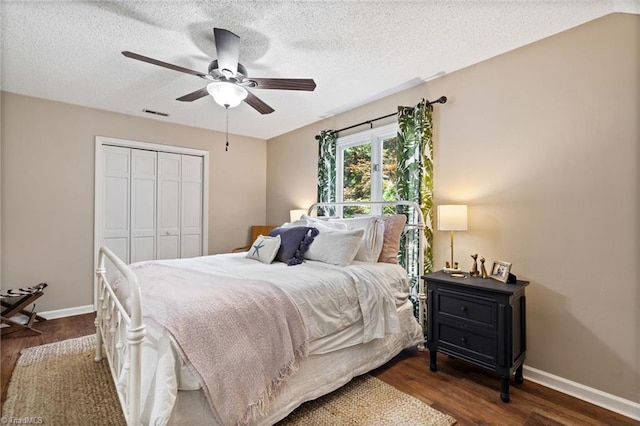 6404 Muirfield Dr, Greensboro, NC 27410 - bedroom featuring a closet, dark wood-style flooring, a textured ceiling, baseboards, and ceiling fan