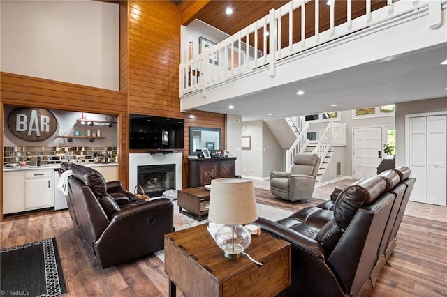 6404 Muirfield Dr, Greensboro, NC 27410 - living room featuring stairs, wood finished floors, a towering ceiling, recessed lighting, and a large fireplace