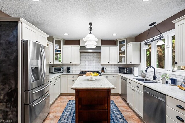 6404 Muirfield Dr, Greensboro, NC 27410 - kitchen with appliances with stainless steel finishes, a sink, tasteful backsplash, a textured ceiling, and hanging light fixtures