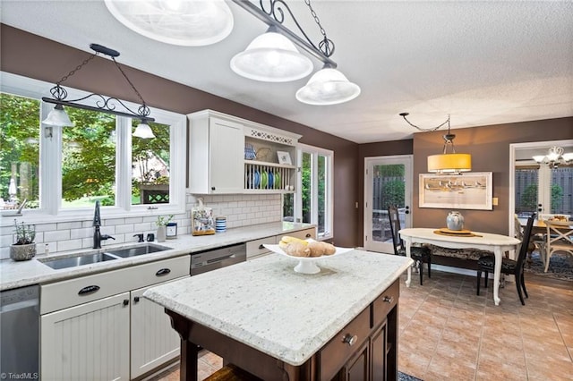 6404 Muirfield Dr, Greensboro, NC 27410 - kitchen featuring a sink, stainless steel dishwasher, open shelves, decorative backsplash, and hanging light fixtures