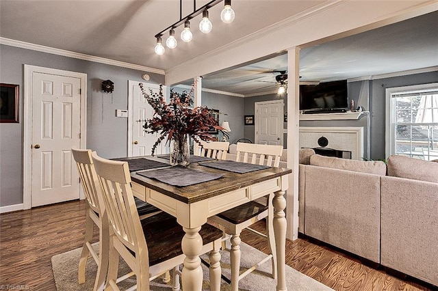 dining room featuring ornamental molding, a brick fireplace, hardwood / wood-style floors, and ceiling fan