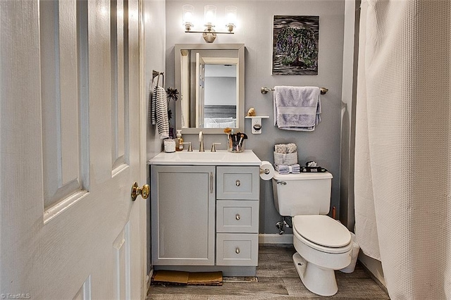 bathroom featuring vanity, hardwood / wood-style floors, and toilet