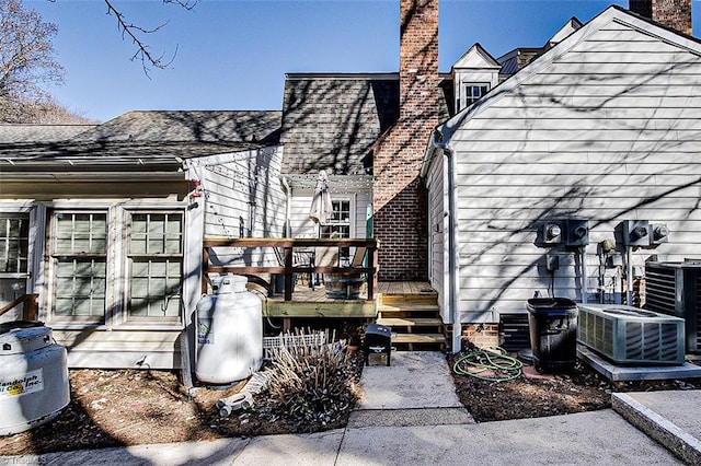 rear view of property with a wooden deck and central air condition unit