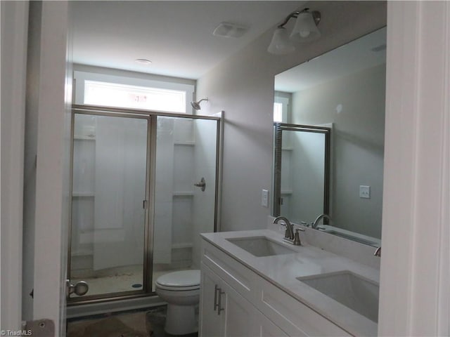 bathroom featuring vanity, toilet, and a shower with door