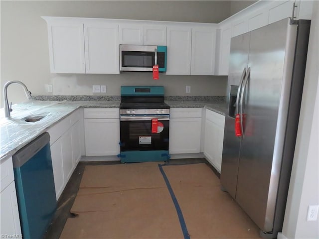 kitchen with stainless steel appliances, white cabinets, and sink