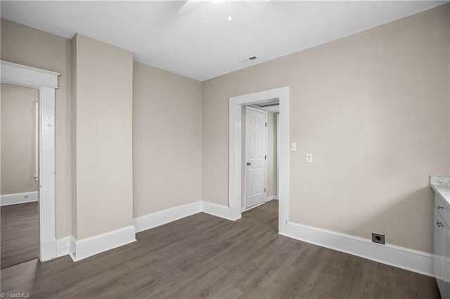 spare room with visible vents, baseboards, and wood finished floors