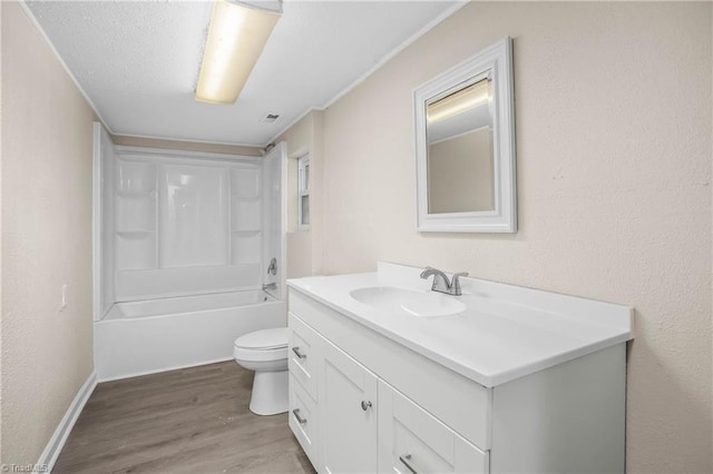 bathroom featuring vanity, wood finished floors, a textured ceiling, toilet, and a textured wall