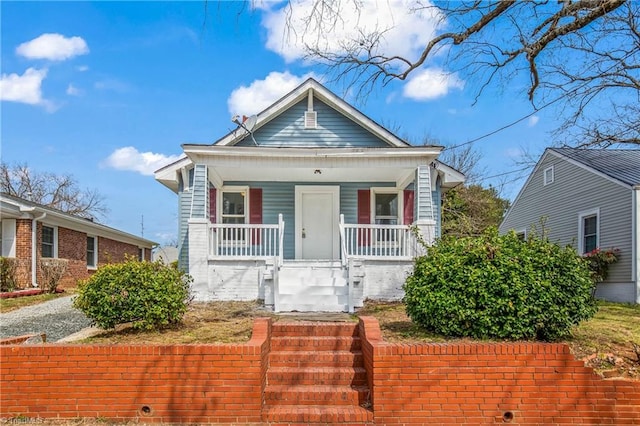 bungalow-style house with stairs and covered porch