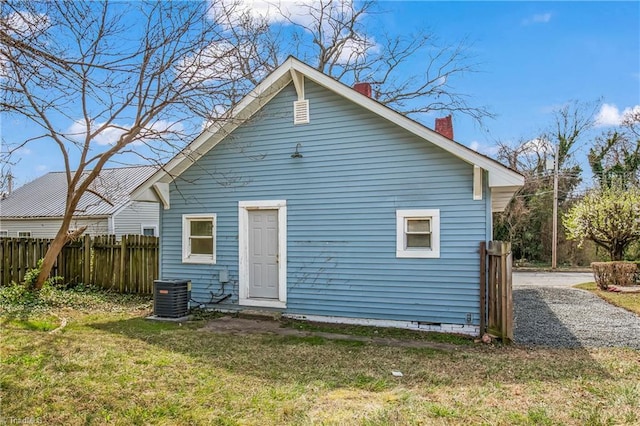 rear view of property with fence, central air condition unit, a lawn, a chimney, and crawl space