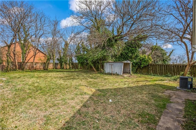 view of yard featuring a storage shed, an outbuilding, and a fenced backyard