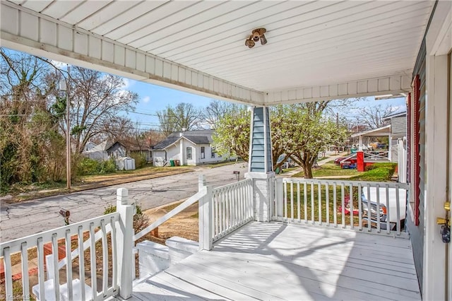 wooden deck with a residential view and covered porch