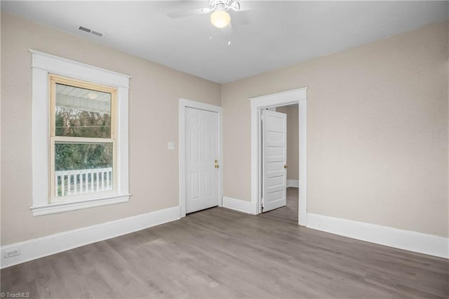 spare room with ceiling fan, baseboards, and wood finished floors