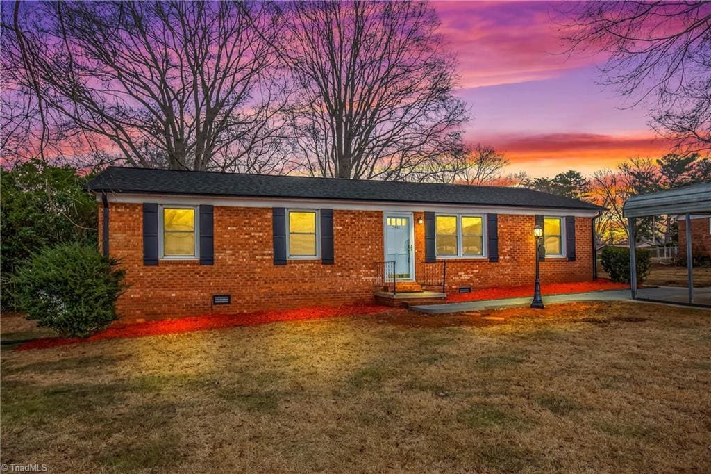 single story home with a carport and a lawn