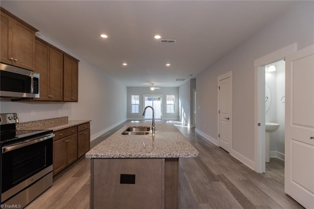 kitchen with visible vents, appliances with stainless steel finishes, dark wood-type flooring, and a sink