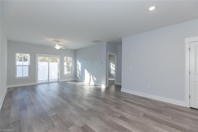 unfurnished living room with visible vents, ceiling fan, baseboards, and wood finished floors