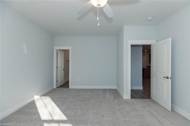 unfurnished bedroom with carpet floors, a ceiling fan, and baseboards