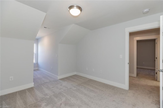 additional living space featuring vaulted ceiling, carpet floors, visible vents, and baseboards