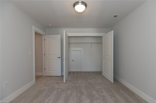 unfurnished bedroom with carpet, visible vents, baseboards, and a closet