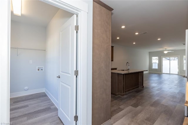 hallway with hardwood / wood-style floors and sink