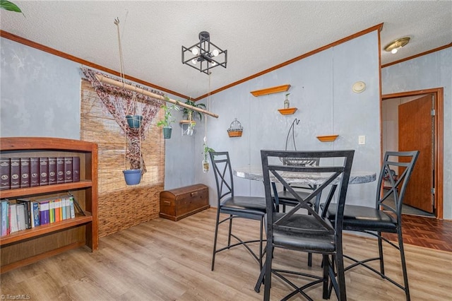 dining area with a textured ceiling, hardwood / wood-style flooring, and crown molding