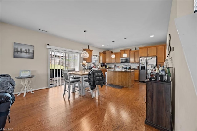 dining space with light wood-style floors, recessed lighting, and baseboards