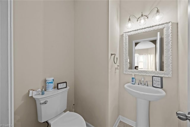 bathroom with toilet and baseboards