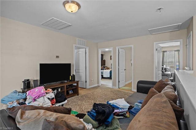 living area featuring attic access, carpet floors, and baseboards