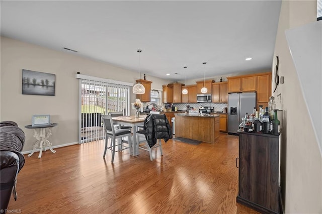dining space with light wood-style flooring, recessed lighting, and baseboards