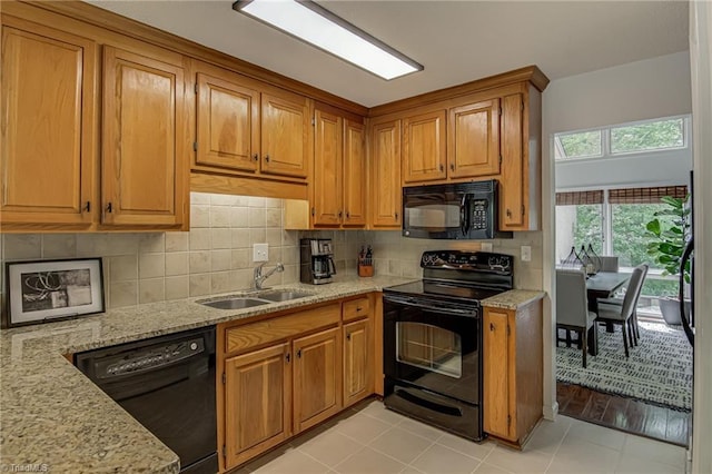 1935 Eastchester Dr Unit B, High Point, NC 27265 - kitchen with black appliances, a sink, light stone countertops, and brown cabinets
