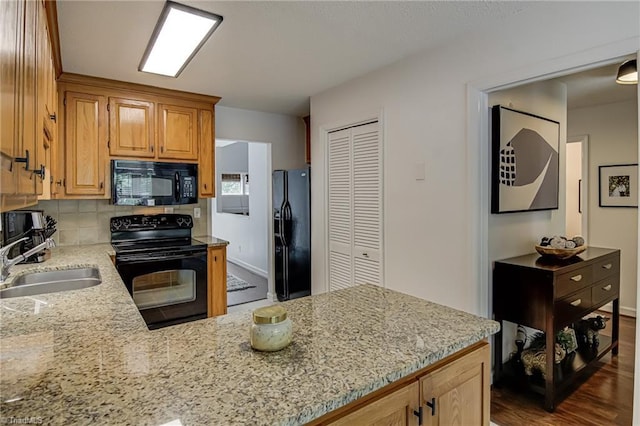 1935 Eastchester Dr Unit B, High Point, NC 27265 - kitchen featuring black appliances, a sink, light stone countertops, decorative backsplash, and a peninsula