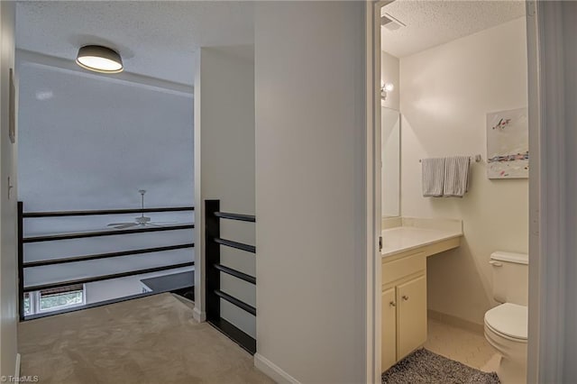 1935 Eastchester Dr Unit B, High Point, NC 27265 - bathroom with a textured ceiling, vanity, toilet, baseboards, and ceiling fan