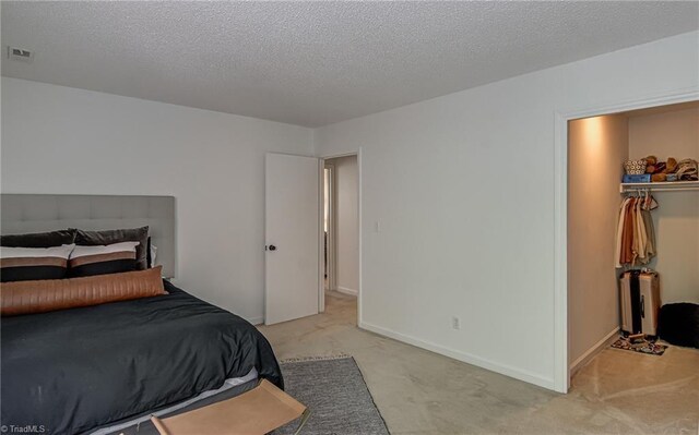 1935 Eastchester Dr Unit B, High Point, NC 27265 - carpeted bedroom with a walk in closet, a textured ceiling, a closet, and baseboards