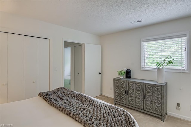 1935 Eastchester Dr Unit B, High Point, NC 27265 - bedroom featuring light colored carpet, baseboards, a textured ceiling, and a closet