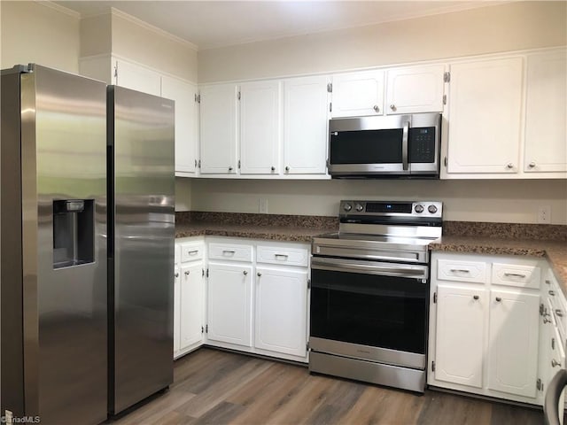 3960 Wards Gap, Cana, VA 24317 - kitchen with appliances with stainless steel finishes, white cabinetry, dark wood finished floors, dark countertops, and crown molding