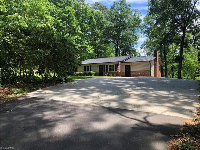 3960 Wards Gap, Cana, VA 24317 - view of front facade featuring a chimney, concrete driveway, brick siding, and metal roof