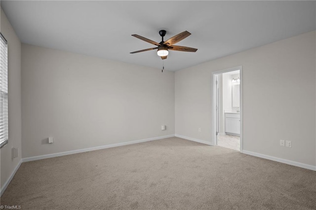 spare room featuring light carpet and ceiling fan