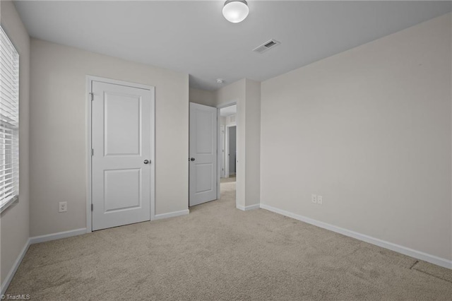 unfurnished bedroom with light colored carpet