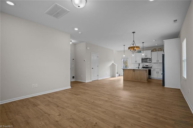 unfurnished living room with light wood-type flooring and sink