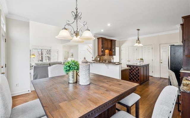 dining room featuring crown molding, dark hardwood / wood-style flooring, and a notable chandelier