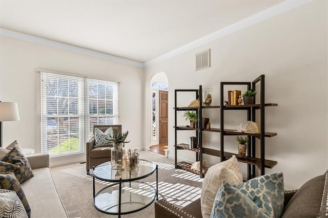 living room with ornamental molding, light colored carpet, and a healthy amount of sunlight