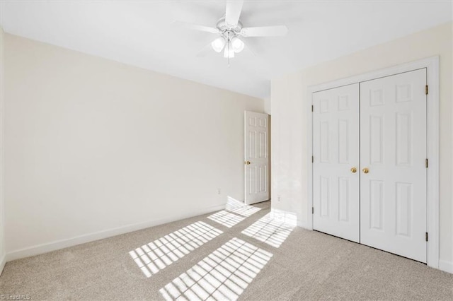 unfurnished bedroom with ceiling fan, light colored carpet, and a closet