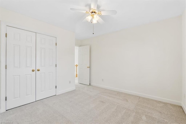 unfurnished bedroom with ceiling fan, light colored carpet, and a closet