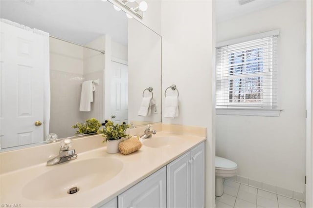 bathroom with tile patterned flooring, vanity, and toilet