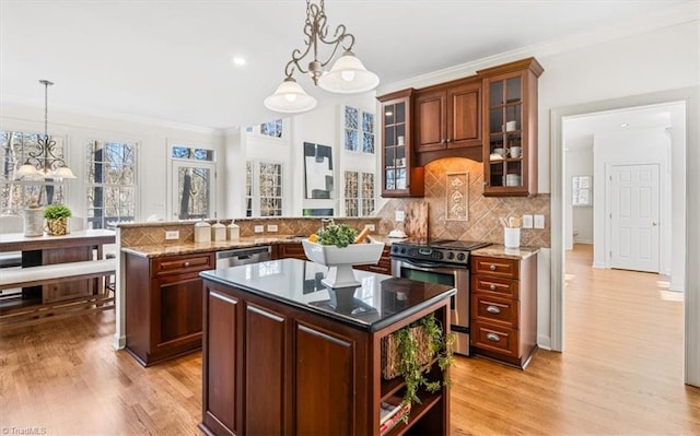 kitchen featuring kitchen peninsula, appliances with stainless steel finishes, an inviting chandelier, and pendant lighting