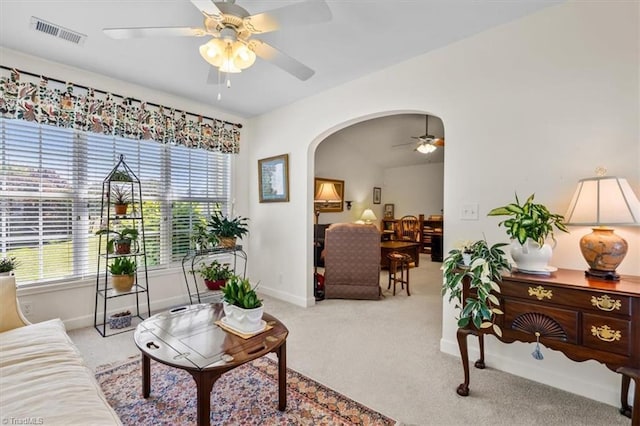 2105 Rosemont Dr, Colfax, NC 27235 - carpeted living room featuring a ceiling fan, arched walkways, plenty of natural light, and baseboards