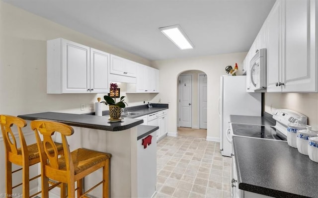 2105 Rosemont Dr, Colfax, NC 27235 - kitchen with white appliances, arched walkways, a breakfast bar area, a peninsula, and white cabinets
