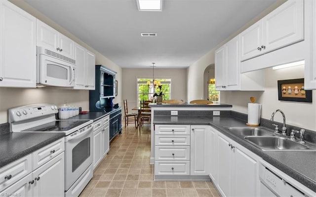 2105 Rosemont Dr, Colfax, NC 27235 - kitchen featuring white appliances, a sink, white cabinetry, dark countertops, and a peninsula