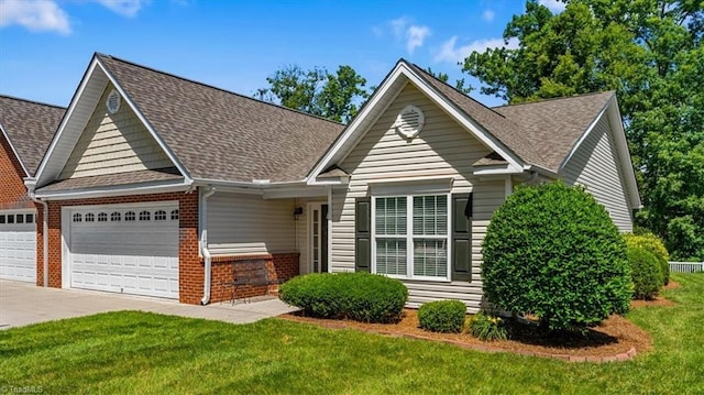 2105 Rosemont Dr, Colfax, NC 27235 - view of front of property featuring brick siding, an attached garage, a shingled roof, driveway, and a front yard