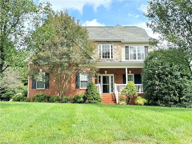 colonial inspired home featuring a front yard and a porch